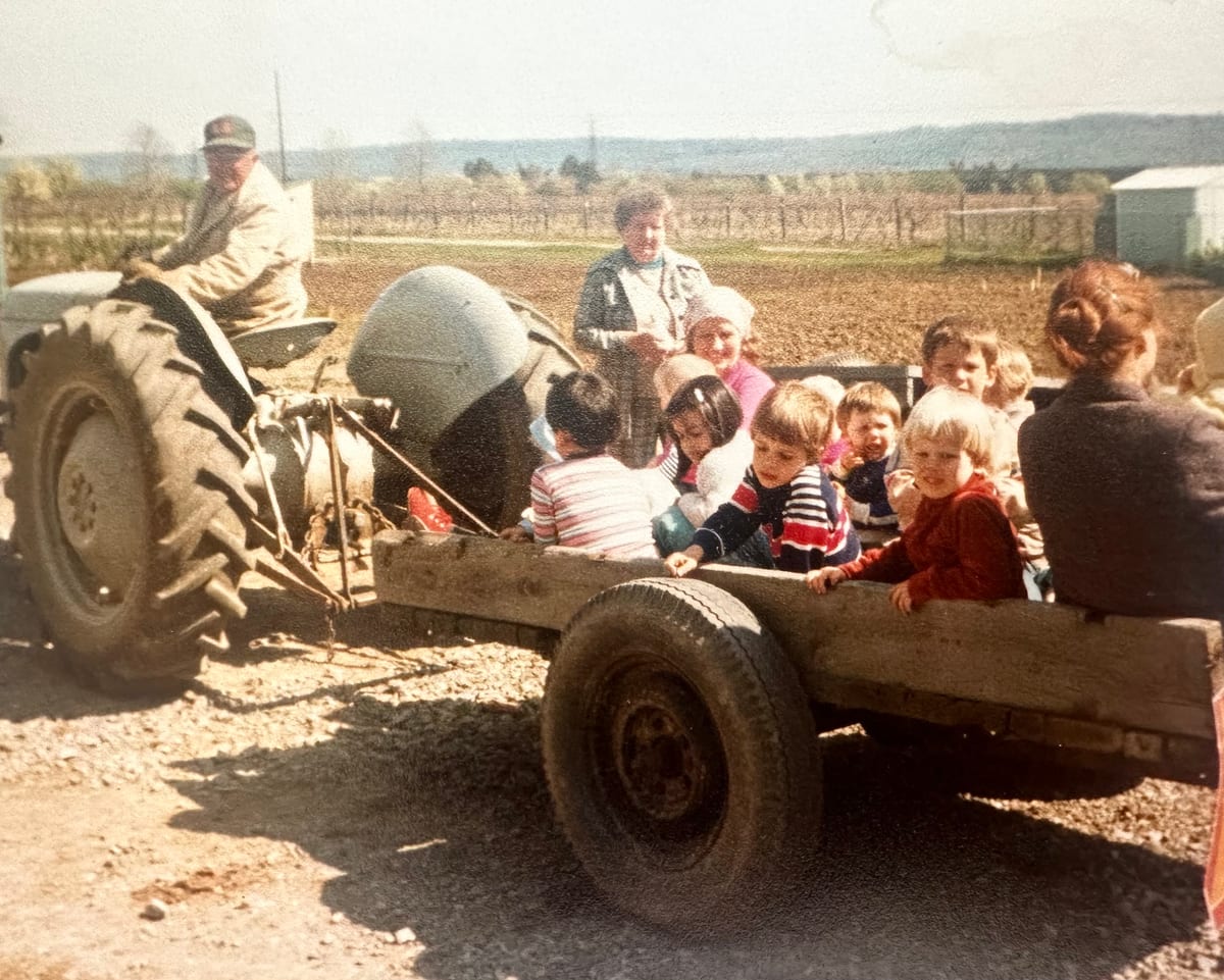 Children riding in a farm wagon pulled by a tractor
